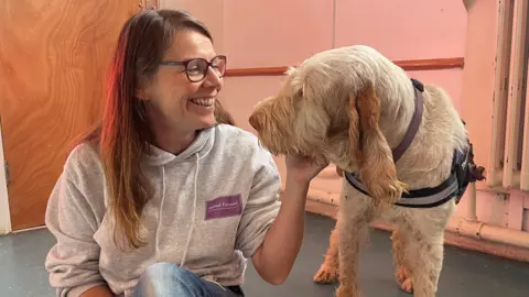 CHARLOTTE VOWDEN/BBC Vicky Skinner smiles fondly at Hero the therapy dog