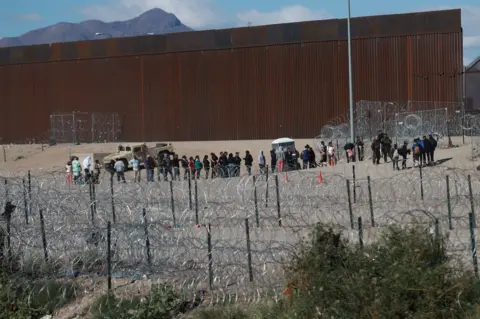 EPA Migrants at the US southern border wall in Juarez City, Mexico
