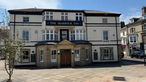 Andrew Turner/BBC The Harbour Inn built in the Georgian style. It features sash and casement windows over three storeys, with masonry and brickwork forming a decorative entrance in the centre of the building. The ground floor is a pub, with the upper floor used as a nightclub venue - which will close on Saturday.