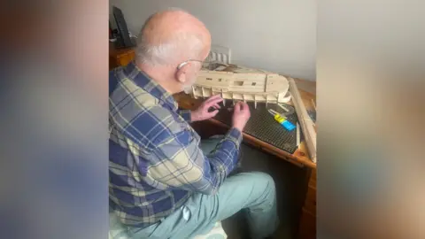 Other Mr Holmes sat at a table crafting a model out of matchsticks