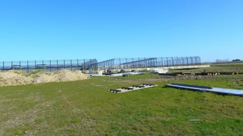 Wingham Wildlife Park Construction work at a wildlife park. There are large metal frames and logs on the site. 
