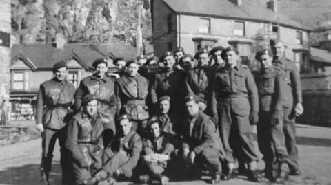 Prof Leah Garrett Black and white 1940s photo of group of soldiers standing in front of houses