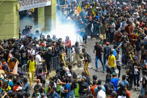 Getty Images Police fire tear gas at protesters on a street leading to Sri Lanka'a Presidential Palace