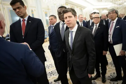 Getty Images Sam Altman stands next to other officals in a building in Riyahd