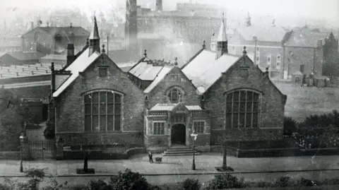 Photograph of the Touchstones Rochdale library in 1894. The image is from the Rochdale Council archives and includes factory chimneys in the background.  