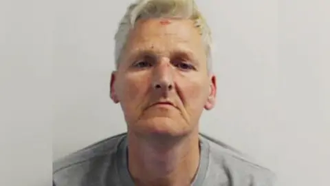 A police mug shot of William Feely, a man with greying hair