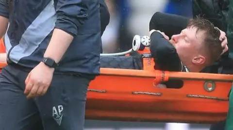 Andy Cannon is carried off on a stretcher