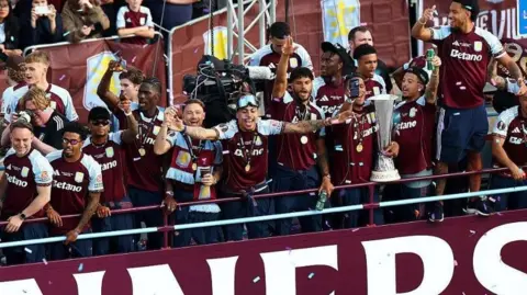 Villa players celebrate in their kit atop a double decker bus