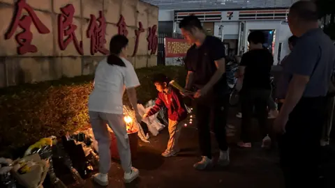 Reuters Members of the public leaving flowers and other tributes outside the stadium on Tuesday