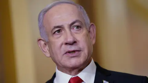 Israeli Prime Minister Benjamin Netanyahu  looks to the right of the camera with pursed lips