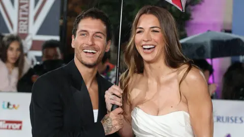 Getty Images Gorka Márquez and Gemma Atkinson smiling together and holding an umbrella on the red carpet at the Pride Of Britain Awards 2025 
