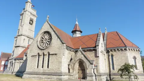 Hartlepool Art Gallery. The picture shows one of the entrances to the former church building at the side of the building. The clock tower stands to the left of the church building.