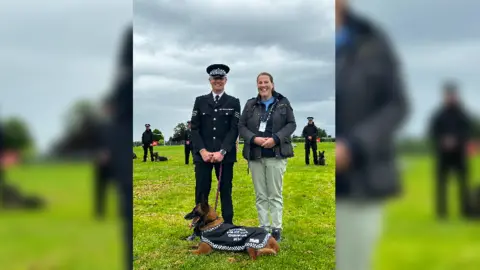 Avon and Somerset Police Sergeant Nick Dalrymple stands with a judge at the police dog trials, with Eva lying down