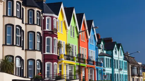 Getty Images A row of colourful attached houses under a blue sky