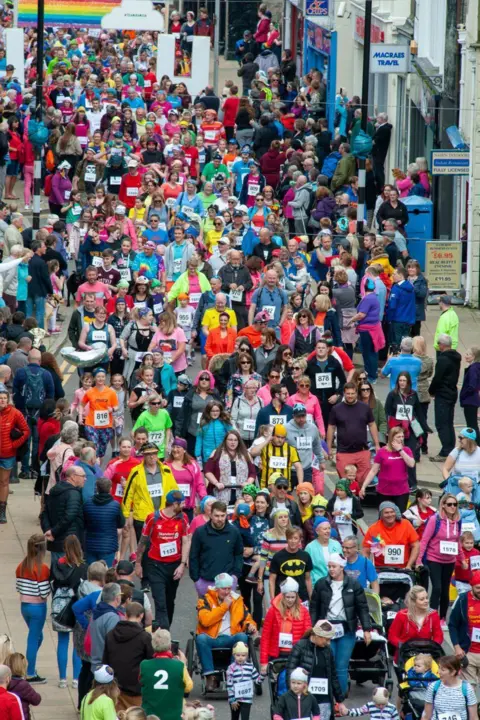 Marc Marnie Dozens of people in colourful clothing gathered in Nairn for a run in honour of Hamish