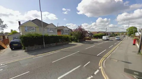Google Streetview of junction of Heath Avenue and Wimborne Road - a wide two-way road with semi-detached houses on either side 