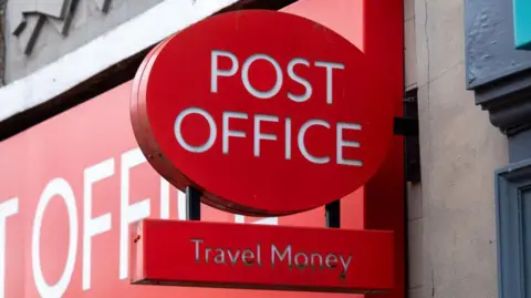 A Post Office sign on a UK high street