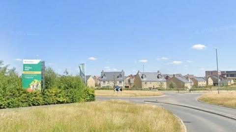 Homes on a new estate with Persimmon sign and grass traffic island