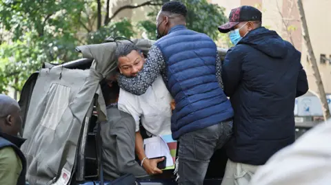 John Muchucha / Reuters Executive director of Amnesty is grabbed and detained by plainclothes policemen and bundled into a vehicle in Nairobi, Kenya - Tuesday 10 December 2024