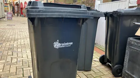 BBC/Henry Godfrey-Evans 3 black bins on Braintree high street