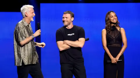 Jesse Grant / Getty Images para Disney James Cameron, Sam Worthington e Zoe Saldana aparecem no Disney Entertainment Showcase no D23: The Ultimate Disney Fan Event em Anaheim, Califórnia, em 9 de agosto de 2024