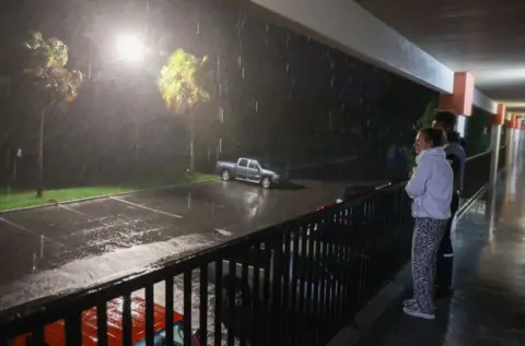 Getty Images People watch rain fall as Hurricane Debby approaches Florida 