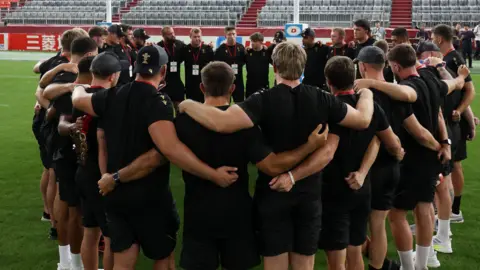 Wales players in a huddle at the Noevir Stadium