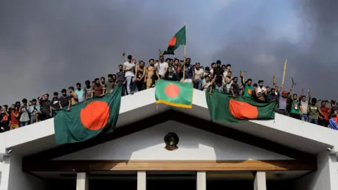 Getty Images Demonstranten bestormen het paleis van premier Sheikh Hasina nadat ze het land was ontvlucht