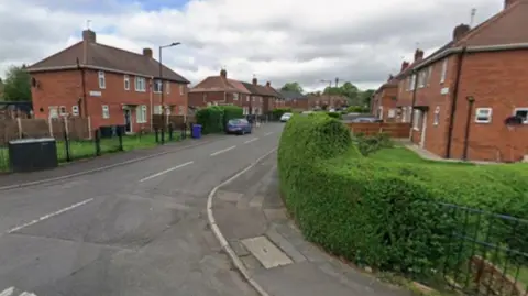 A street of red brick semi-detached houses
