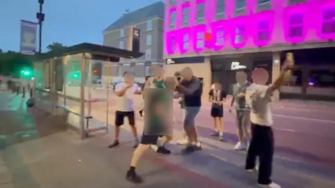 People fighting in a dark street