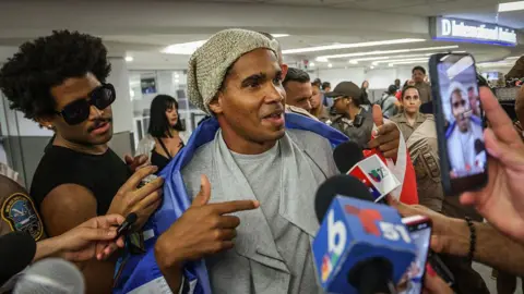 Luis Manuel Otero Alcántara speaks to journalists at Miami airport. 