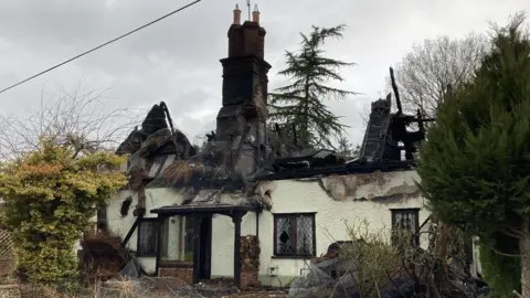 Luke Deal/BBC A view of the damaged property. The cottage's roof has been burnt and collapsed while only the chimney part remains.