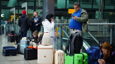Getty Images Passengers stranded and waiting in Heathrow airport in March 2025
