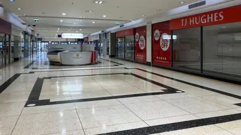 Steve Jones/BBC An empty shopping centre which shows numerous units lying vacant.