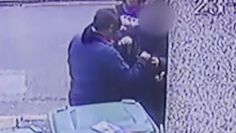 Tuyet van Huynh A grainy still from CCTV footage showing Tuyet's mother handing over a plastic bag containing her valuables to be blessed by a scammer.