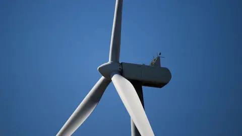 Close up shot of the top section of a white industrial wind turbine.