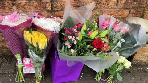 Flowers at the corner of a brick wall