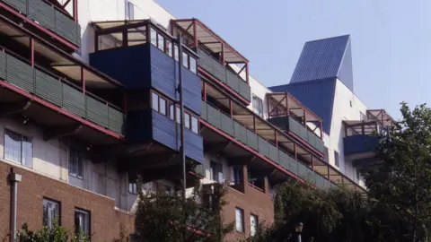 The Byker Wall in Newcastle. The estate is a long wall consisting of number a number of homes. Green balconies run along the building.