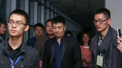 stringer/ Feature China/Future Publishing via Getty Images Zhang Xuefeng, center, arrives for a lecture at Henan University of Technology in Zhengzhou