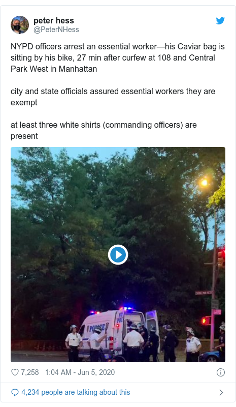 Twitter post by @PeterNHess: NYPD officers arrest an essential worker—his Caviar bag is sitting by his bike, 27 min after curfew at 108 and Central Park West in Manhattancity and state officials assured essential workers they are exemptat least three white shirts (commanding officers) are present