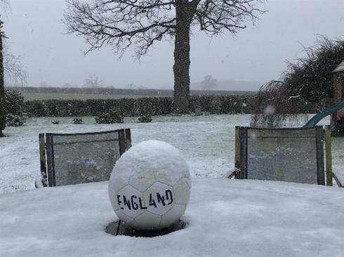 A football on a snowy garden table