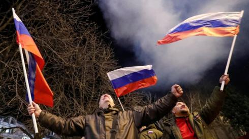 Pro-Russian activists react after Russian President Vladimir Putin signed a decree recognising two Russian-backed breakaway regions in eastern Ukraine as independent entities, in the separatist-controlled city of Donetsk, Ukraine February 21, 2022.