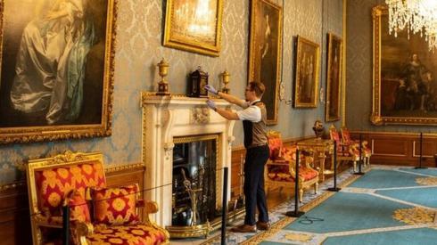 Fjodor changes the time on a clock in a large and beautifully decorated state apartment