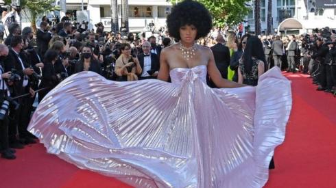 A woman poses in an iridescent dress on the red carpet.