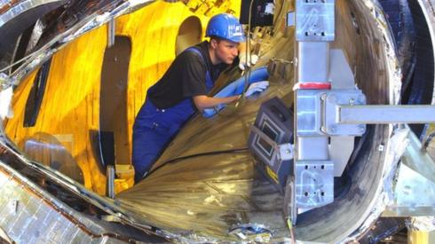 View inside one of the W7X modules. Visible are the plasma vessel, a magnet coil, the outer casing, and numerous ducts for coolant and leads for power