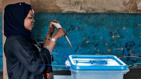 A voter casts a special vote ballot a day early, in line with to electoral dispensations, at a polling station in Zanzibar, on 27 October 2020.