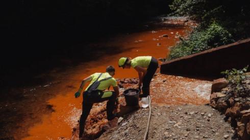 Ecologists from the Ecolive organization take samples of sludge caused by the polluted water flow from the nearby siderite mine shafts near Nizna Slana, Slovakia on August 11 2022