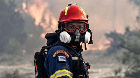 A firefighter looks on during a fire near the village of Vati, just north of the coastal town of Gennadi, in the southern part of the Greek island of Rhodes on July 25, 2023.