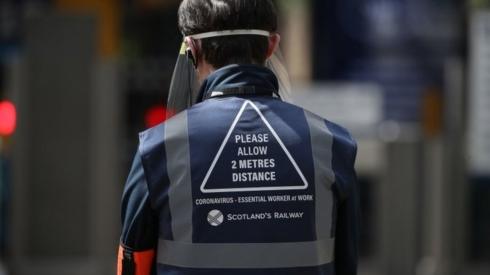 Station worker with notice on back