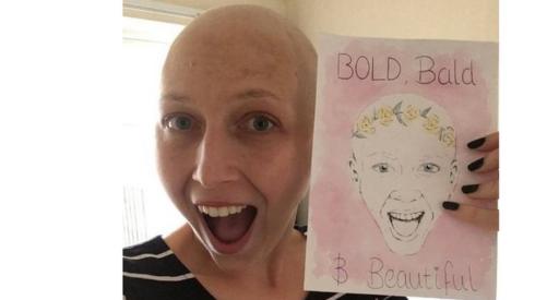 Kirsty Hopgood holding a 'bold, bald and beautiful' card